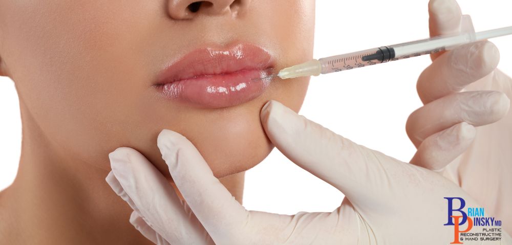 A gloved hand precisely administers a lip injection with a syringe, enhancing beauty with expertise in Long Island's leading clinic for facial dermal fillers.