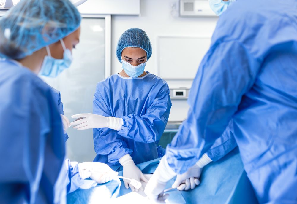 In an operating room, trusted physician Dr. Pinsky and his team conduct a medical procedure, all donning blue scrubs and masks.