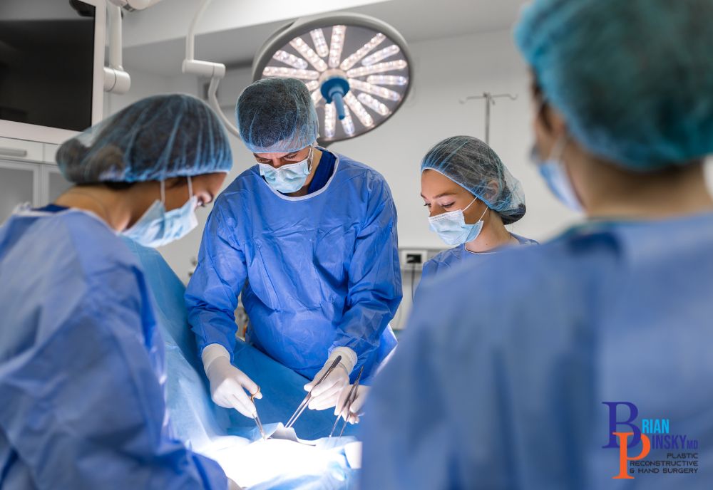 Surgeons in blue scrubs and masks, led by the expert Dr. Pinsky, perform an operation under bright surgical lights in an operating room dedicated to advancing healthcare.