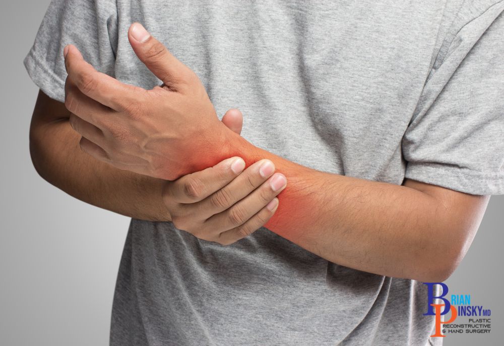 A person clad in a gray t-shirt clutches their wrist, highlighted in red to denote pain. They might be exploring treatments for relief, possibly from a specialist on Long Island.